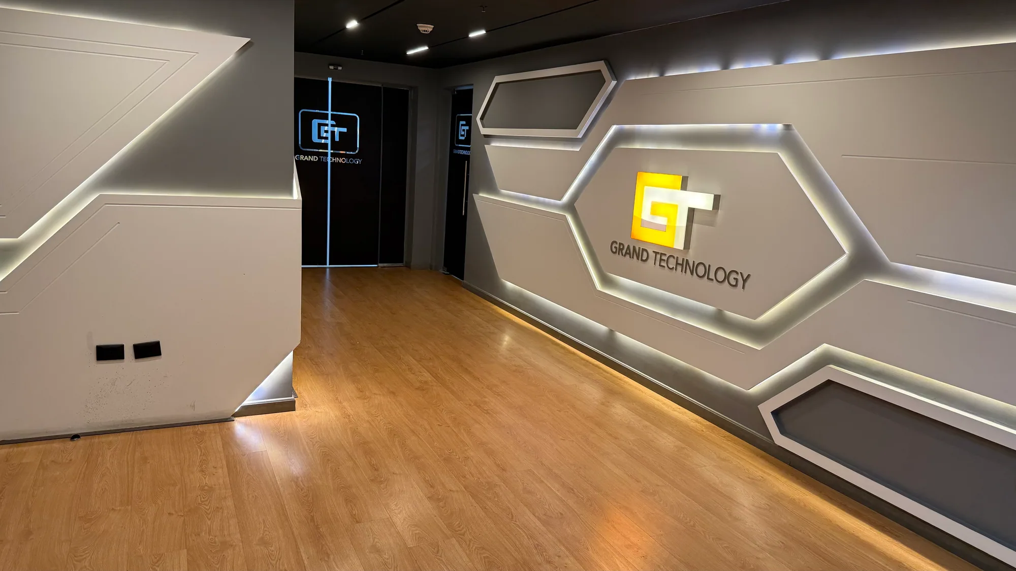 Grand Technology headquarters — the illuminated GT reception wall