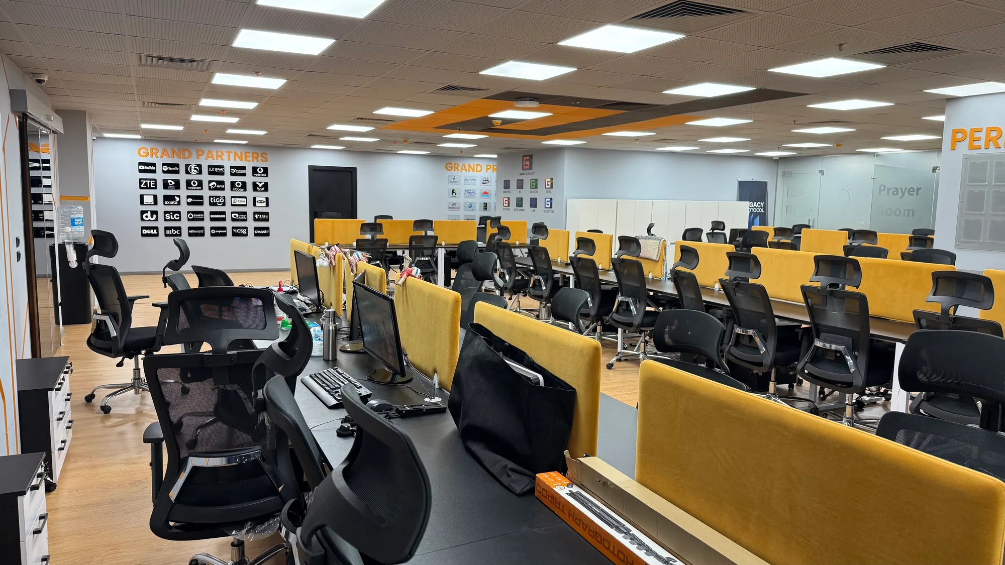 Inside the Grand studio — an open workspace lined with brand-yellow desks